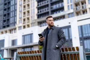 Парень уверенно идёт с телефоном в руке